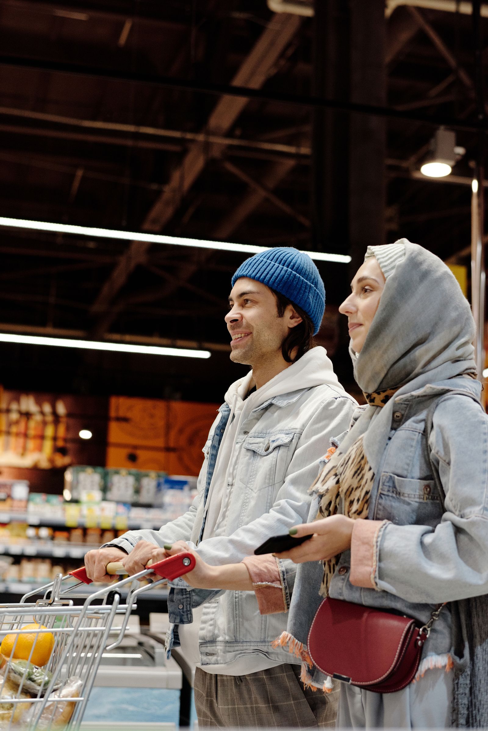 A couple pushing a trolley through a supermarket